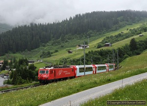 MGB No.104 has just dropped out of the clouds at Dieni on the descent from Oberalppass towards Disentis/Muster with Glacier Express 902 on 16 June 2010.