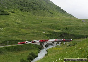 No.104 led westbound Glacier Express 907 over the bridge west of Hospental on 19 June 2010.