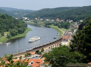 One of ITLs Class 185s led a long train of tank wagons westwards along the Elbe towards Dresden at Königstein on the afternoon of 22 July 2010. On the river, one of Sächsische Dampfshiffahrt's diesel boats had just left the pier to return to Dresden while, in the distance, one of the same company's centenarian paddle steamers headed upriver towards Bad Schandau.