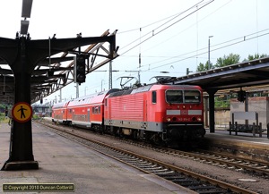 In contrast to the refurbished overall roof and modernised facilities elsewhere in the station, some of Dresden Hbf's low level platforms are semi-derelict. 143.814 ran into the station with RB17325 from Zwickau on 24 July 2010, passing the roofless skeleton of a partially demolished platform canopy.