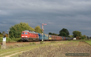 The dark clouds parted at just the right time on the afternoon of 6 October 2010, illuminating 233.450 on a long westbound coal train.