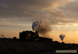 As the sun set on 22 November 2010, JS 8194 rolled off the tips west of Xibolizhan with an empty spoil train.