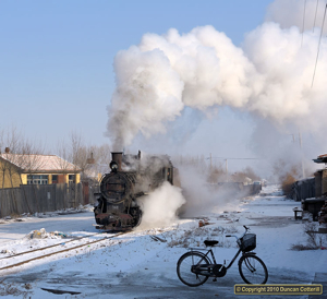 A very leaky 044 trundled through the streets of Huanan with a loaded train on 1 December 2010.