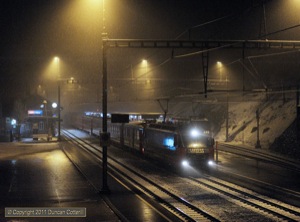 The snow was falling heavily at Filisur on the evening of 20 February 2011 when 648 left with train 1169, the 19:56 from Chur to St. Moritz. In the background 642 waited to leave with train 1860 to Davos.