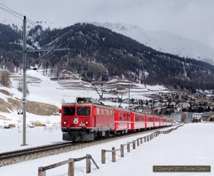RE1125 was booked to be hauled by a Ge4/4i from Samedan to St. Moritz. 608 accelerated the train away from Samedan during a rare sunny break on 22 February 2011. Note the pantograph on the baggage car behind the loco.