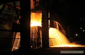 A fireworks display under the furnaces as molten iron cascaded into a waiting ladle.