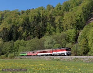 754.069 approached Medzibrod with a colourful consist forming Os7703, the 09:18 from Banska Bystrica to Brezno, on 2 May 2011.
