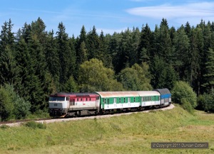749.256 hauled a typical rake of coaches, including a baggage van for the transport of bikes, forming Os8113/8112, the 10:07 from Ceske Budejovice, up the bank towards Nove Udoli on 11 August 2011.
