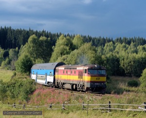 The black clouds were gathering in the west as 749.100 rounded a sharp curve south of Ovesna with Os8127/8126, the 17:17 from Nove Udoli to Ceske Budejovice, on 12 August 2011. 