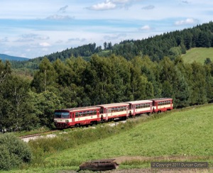 810.575 and 810.641 sandwiched a pair of trailers as they worked uphill towards Horice na Sumave with Os8117/8116, the 12:07 Ceske Budejovice - Nove Udoli passenger, on 14 August 2011.