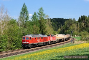 What a difference a week makes! One week and 48 seconds (to be exact) after the previous picture was taken, the trees were in leaf and the fields had been transformed by a carpet of dandelions. 232.675 led train 56908, the afternoon Amberg - Nürnberg freight, down the bank from Etzelwang at Lehendorf on 2 May. 294.717, coupled behind the Ludmilla, was dead in transit.