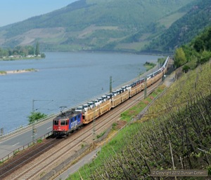 421.385, an SBB Cargo Re4/4ii, hauled a train of new Volkswagens through the Rhein Gorge north of Assmannshausen on 8 May. 