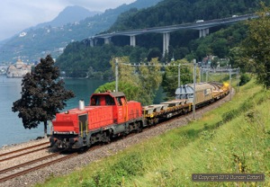 841.003 skirted the shore of Lac Léman north of Villeneuve with 56579, the 10:45 Vevey - Villeneuve trip freight, on 5 September 2012. On the left Château Chillon can be seen behind the trees, unfortunately not as prominent as the motorway viaduct in the background.
